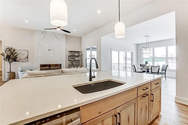 kitchen with ceiling fan, sink, light brown cabinets, light hardwood / wood-style flooring, and pendant lighting