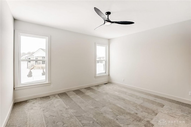 empty room with ceiling fan and light carpet