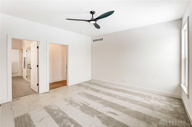 unfurnished bedroom featuring ceiling fan and connected bathroom