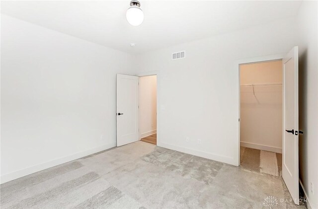 unfurnished bedroom with a spacious closet and a closet