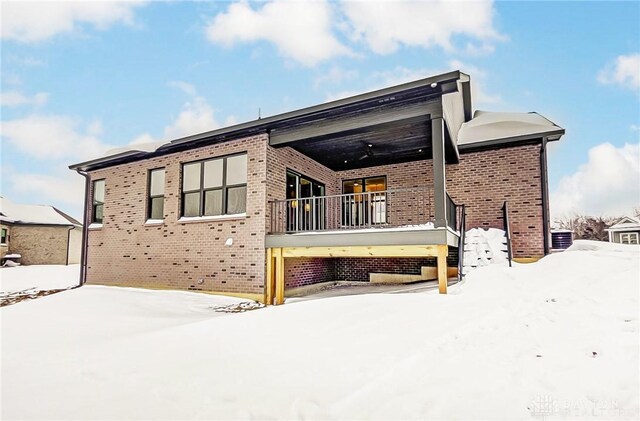 view of snow covered back of property