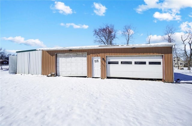 snow covered garage featuring a garage