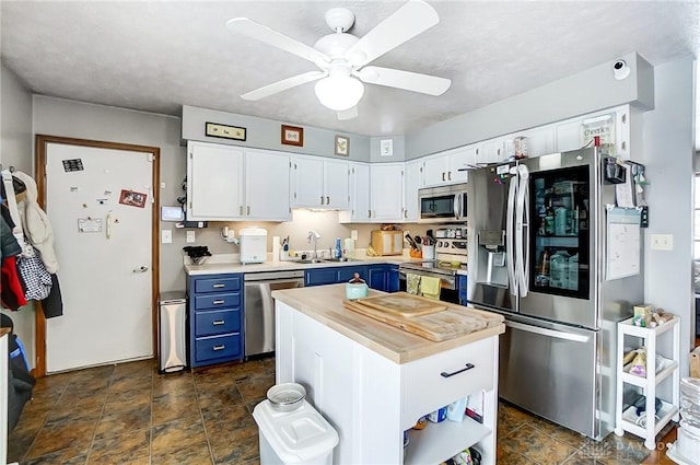 kitchen featuring blue cabinetry, a center island, sink, stainless steel appliances, and white cabinets