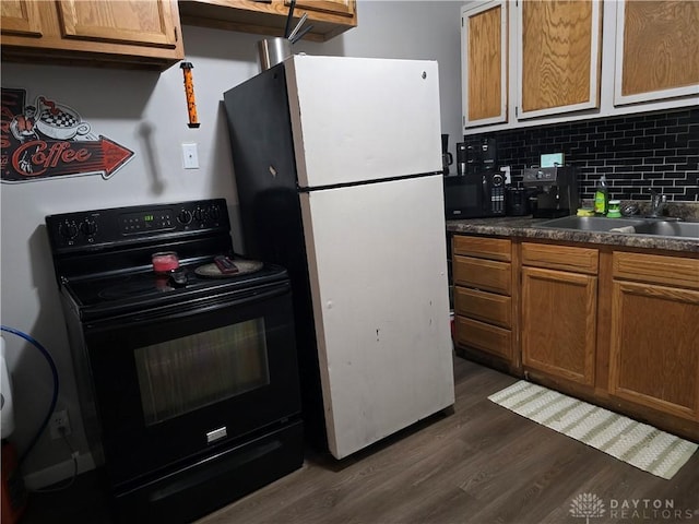 kitchen featuring black appliances, dark hardwood / wood-style floors, sink, and tasteful backsplash