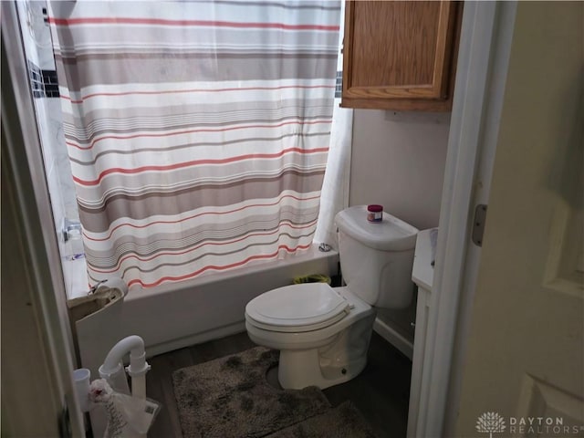 bathroom with hardwood / wood-style flooring, toilet, and shower / bath combo with shower curtain