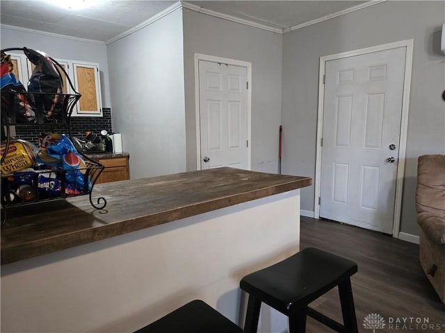 bar featuring wood counters, backsplash, dark wood-type flooring, and ornamental molding