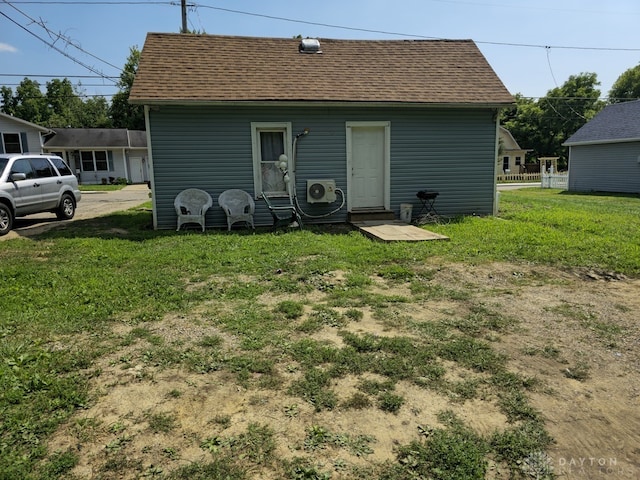 back of property with a lawn and ac unit