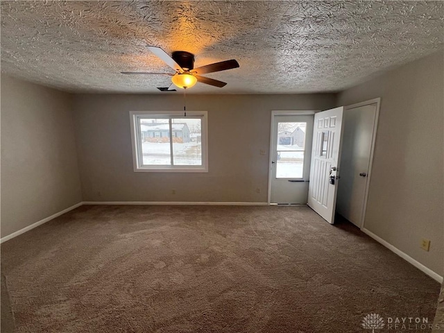 carpeted spare room featuring a wealth of natural light and ceiling fan