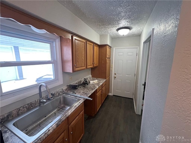 kitchen featuring a textured ceiling, dark hardwood / wood-style flooring, and sink