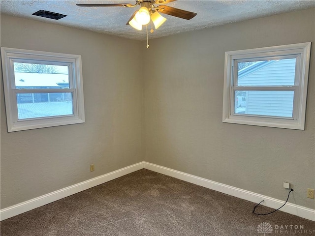 carpeted spare room featuring ceiling fan and a textured ceiling