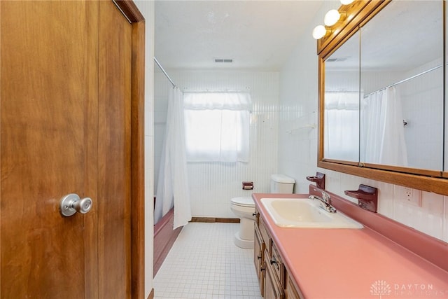 full bath featuring visible vents, toilet, tile patterned flooring, shower / bath combo with shower curtain, and vanity