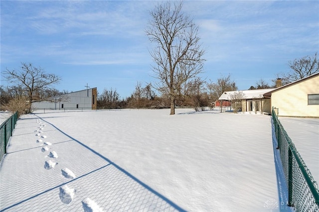 yard covered in snow featuring fence