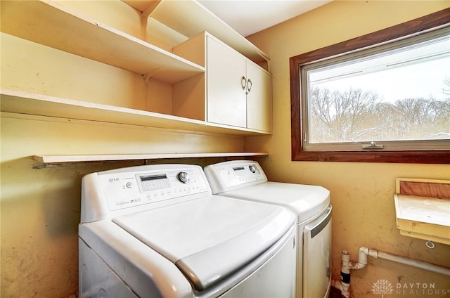 washroom featuring washer and clothes dryer and cabinets