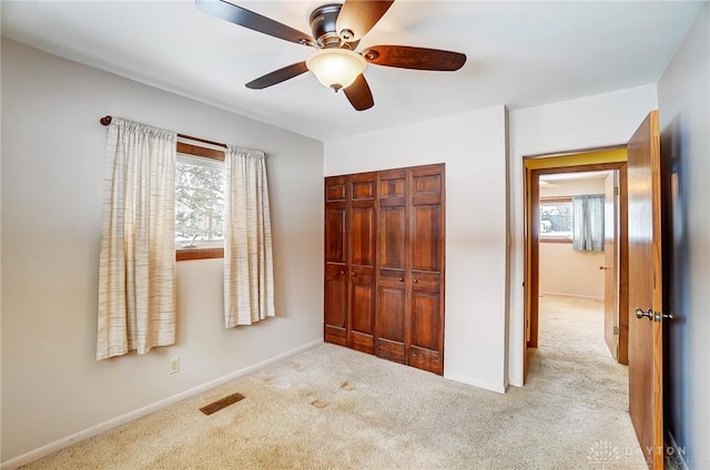 unfurnished bedroom with ceiling fan, a closet, and light colored carpet