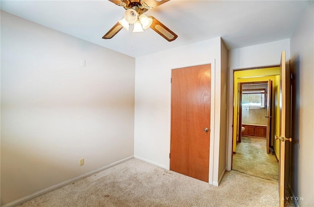 unfurnished bedroom featuring ceiling fan and light colored carpet