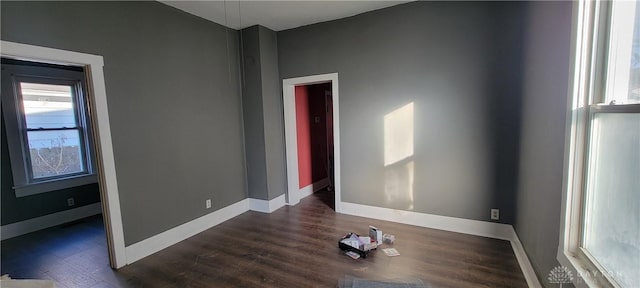 unfurnished room with dark wood-type flooring