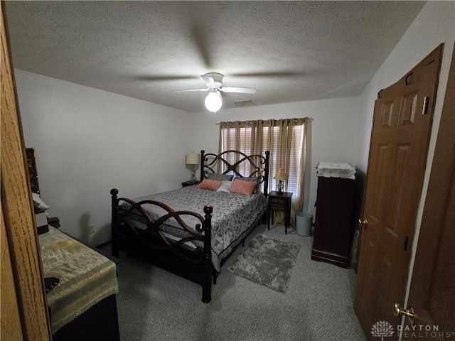 bedroom with a textured ceiling, carpet floors, and ceiling fan