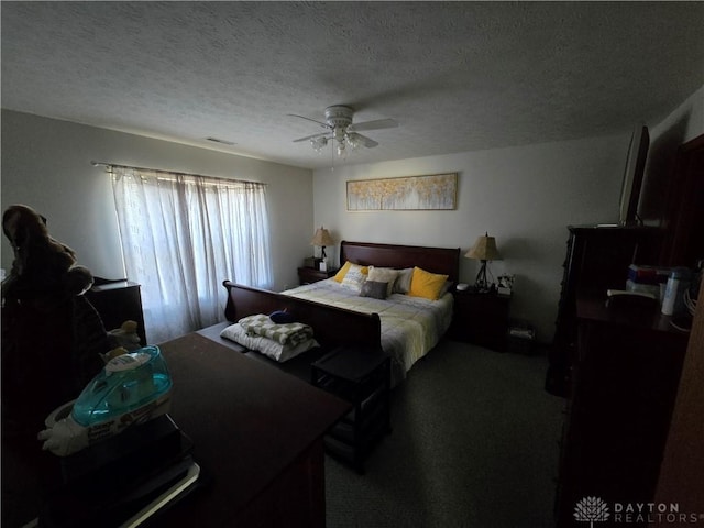 bedroom with a textured ceiling, carpet floors, and ceiling fan