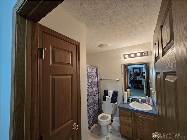 bathroom with a shower with shower curtain, vanity, toilet, and a textured ceiling