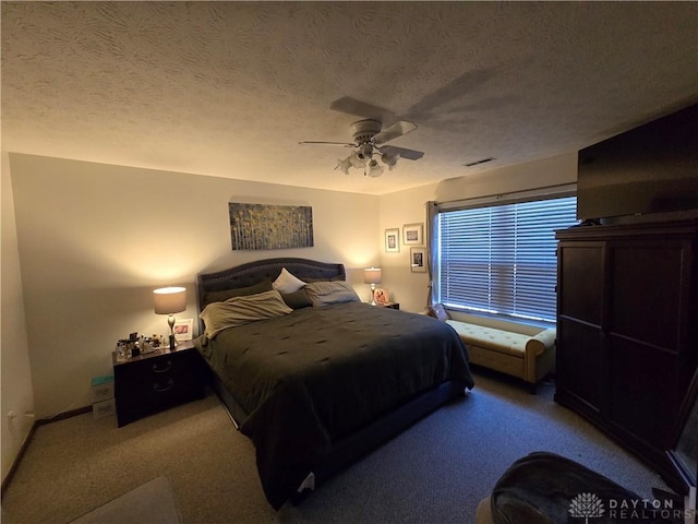 bedroom featuring carpet, ceiling fan, and a textured ceiling