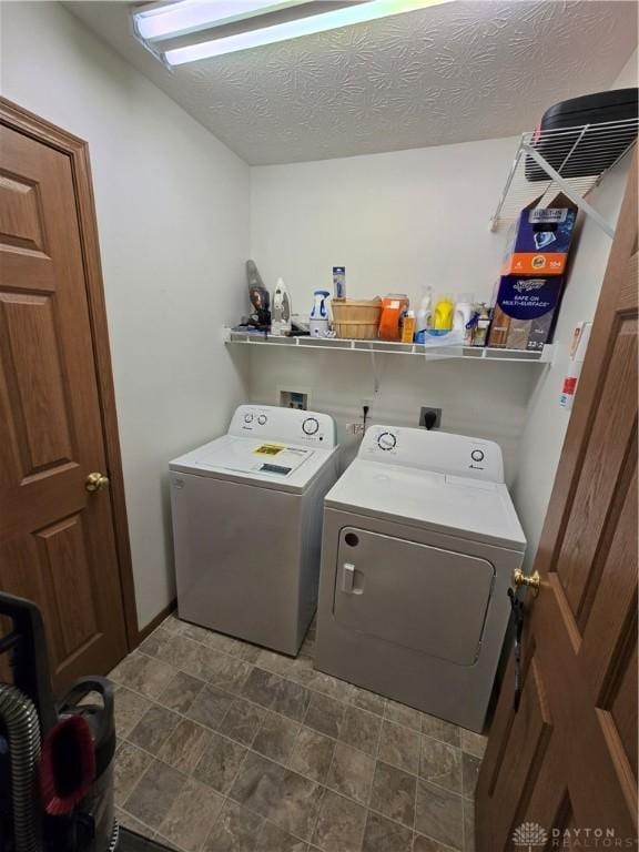 washroom with separate washer and dryer and a textured ceiling