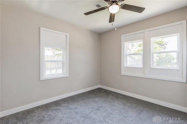 carpeted spare room featuring ceiling fan and plenty of natural light