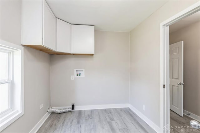 laundry area featuring light hardwood / wood-style floors, cabinets, and hookup for a washing machine