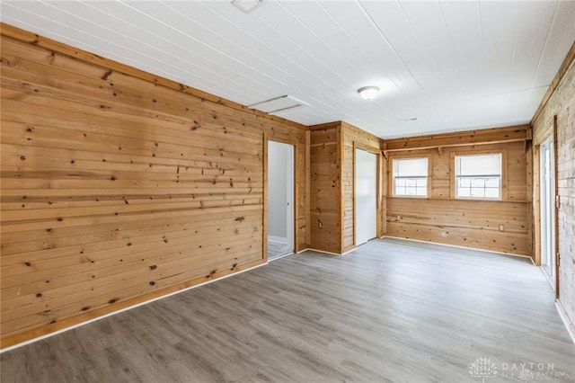 unfurnished room featuring hardwood / wood-style flooring and wood walls