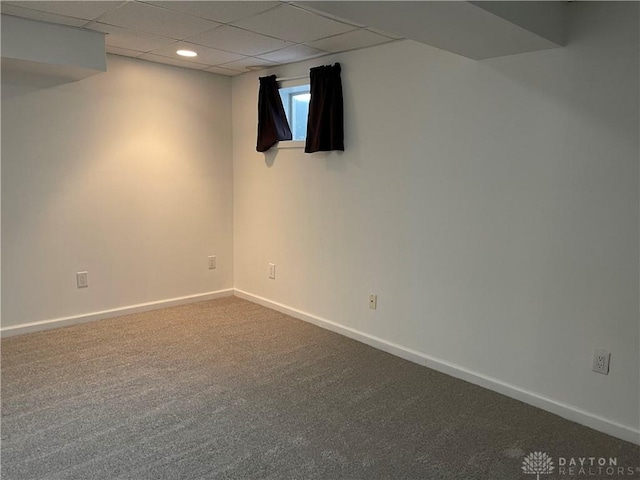 basement featuring carpet and a paneled ceiling