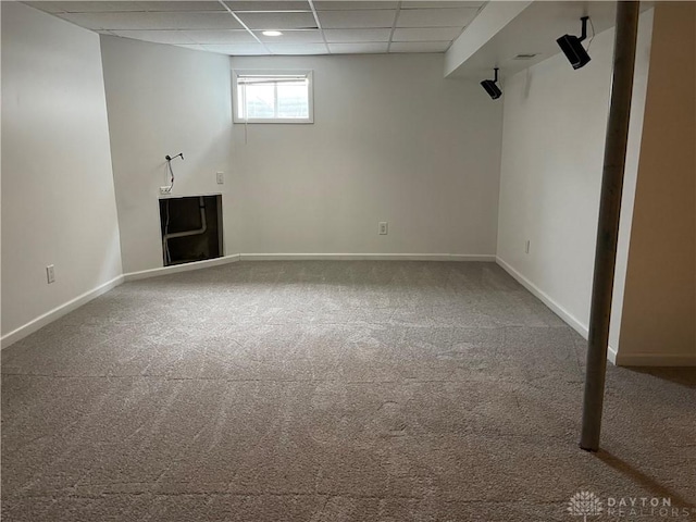 basement featuring carpet and a drop ceiling