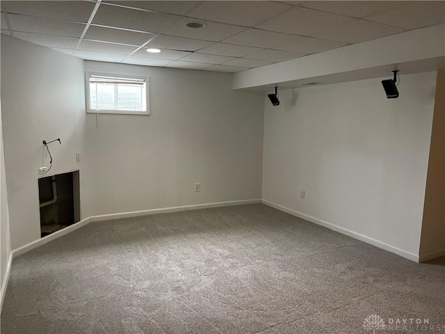 basement featuring carpet flooring and a paneled ceiling