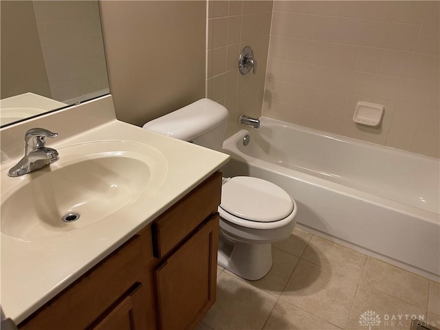 full bathroom featuring tile patterned floors, vanity, tiled shower / bath, and toilet