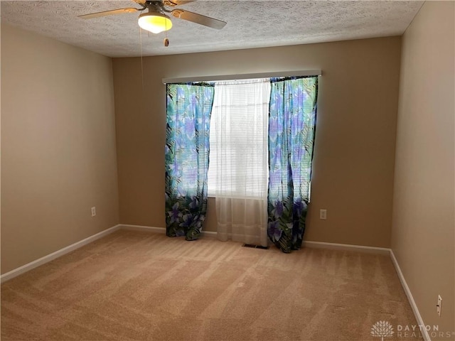 carpeted empty room featuring ceiling fan and a textured ceiling