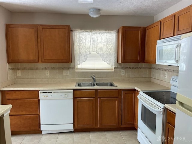 kitchen featuring light tile patterned flooring, white appliances, sink, and tasteful backsplash