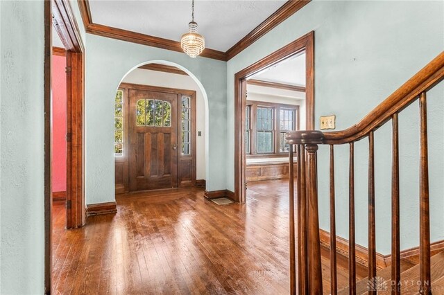 entrance foyer with hardwood / wood-style flooring and ornamental molding