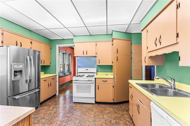 kitchen featuring sink, a drop ceiling, and white appliances