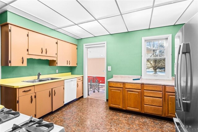 kitchen with stainless steel refrigerator, dishwasher, a drop ceiling, sink, and range