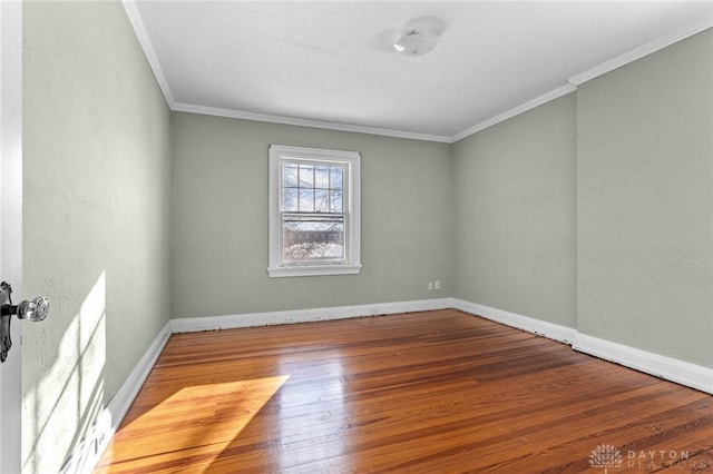 spare room featuring ornamental molding and hardwood / wood-style flooring