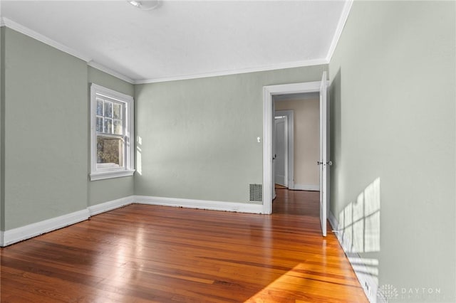 spare room featuring ornamental molding and hardwood / wood-style flooring