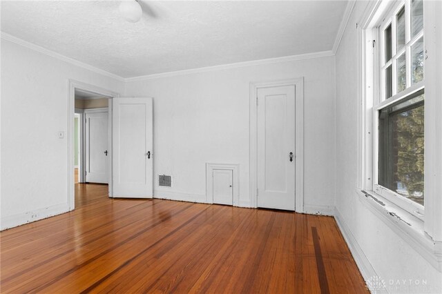 unfurnished room with hardwood / wood-style flooring, plenty of natural light, and ornamental molding