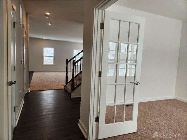 corridor featuring dark colored carpet