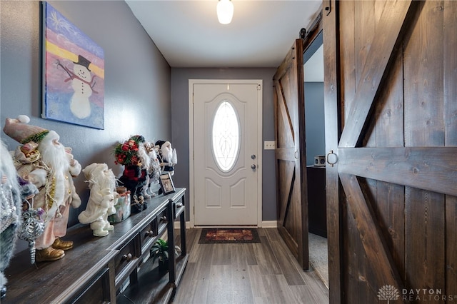 foyer with a barn door and hardwood / wood-style floors