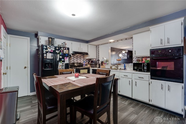 kitchen with decorative backsplash, dark hardwood / wood-style floors, white cabinets, and black appliances