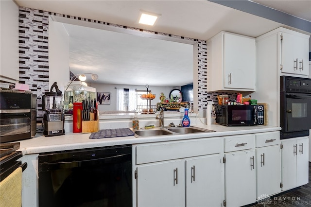 kitchen featuring sink, black appliances, and white cabinets