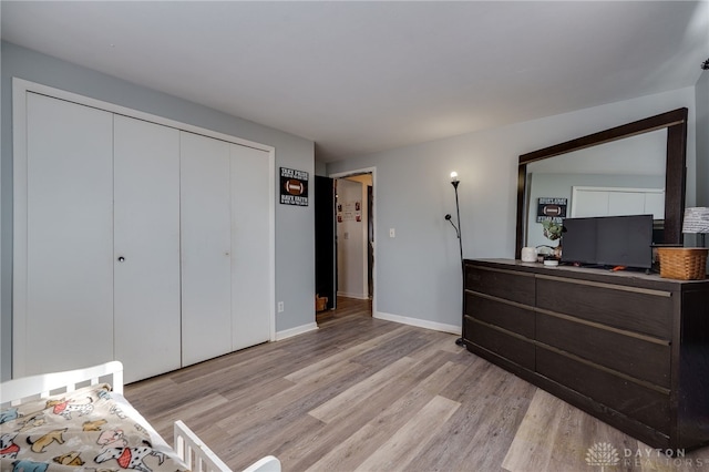 bedroom with light hardwood / wood-style flooring and a closet