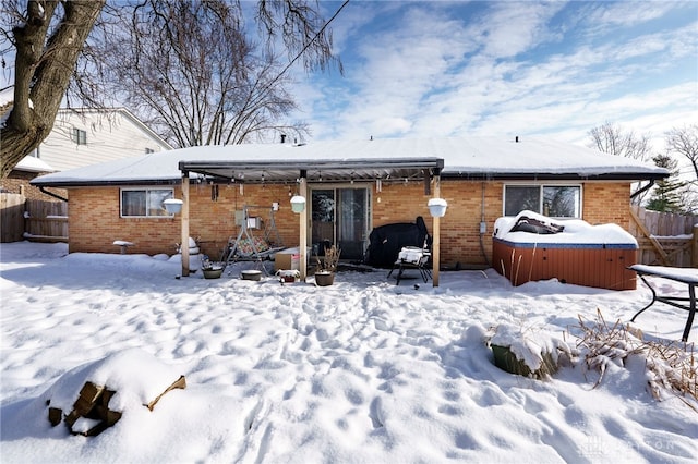 snow covered house featuring a jacuzzi