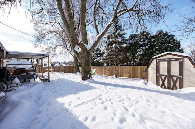 yard layered in snow featuring a storage unit