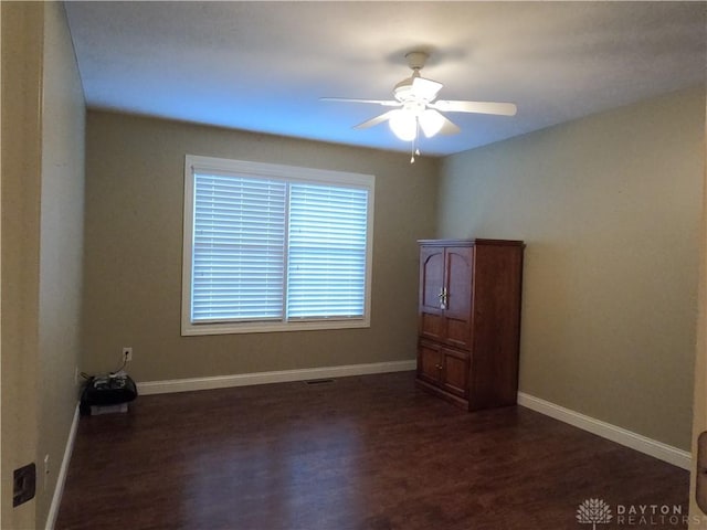 spare room with dark hardwood / wood-style floors and ceiling fan