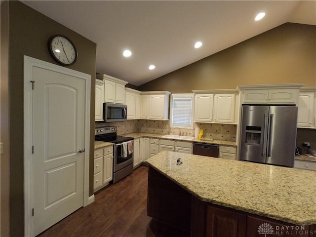 kitchen featuring light stone countertops, appliances with stainless steel finishes, tasteful backsplash, sink, and white cabinetry