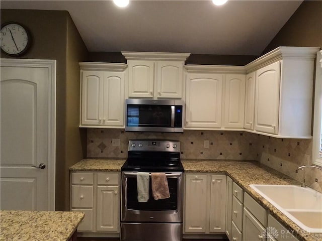 kitchen featuring white cabinets, appliances with stainless steel finishes, backsplash, and sink